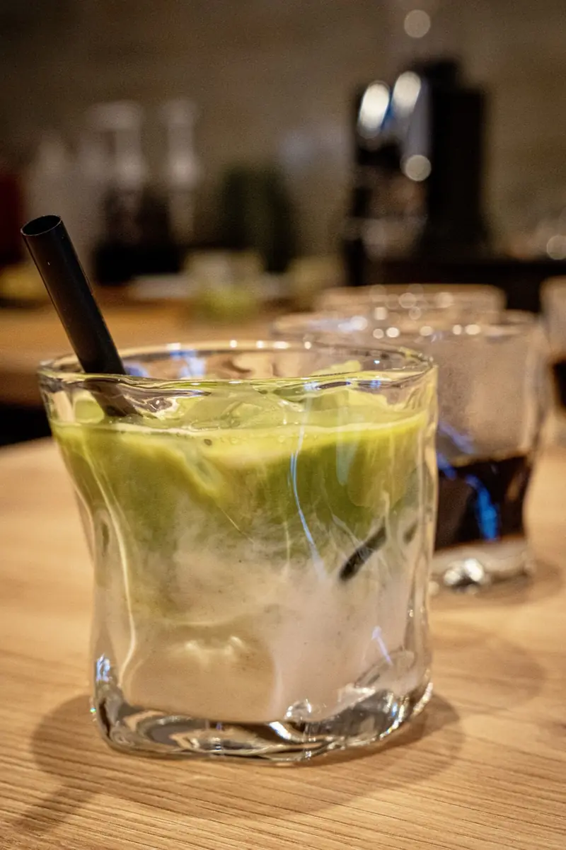 Iced Matcha im Glas mit Strohhalm