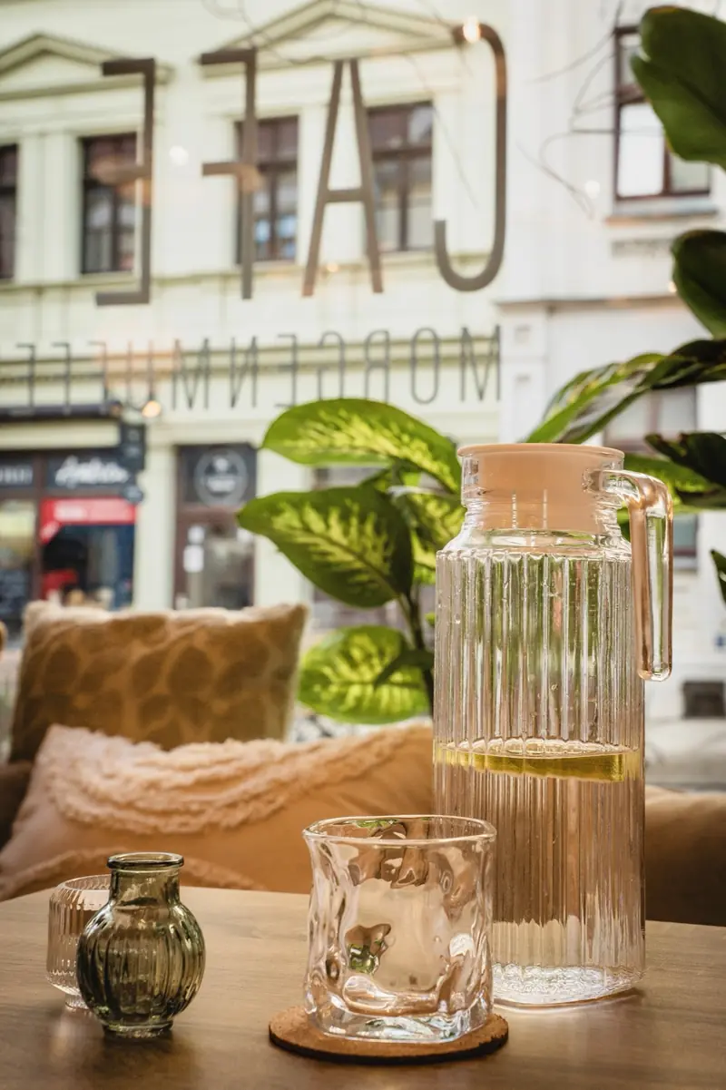 Wasserkaraffe und Glas am Fensterplatz